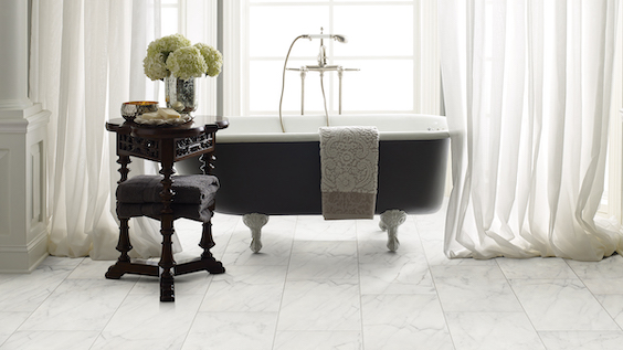 elegant white marble tile flooring in a classy bathroom with a stand alone tub in front of a bright window